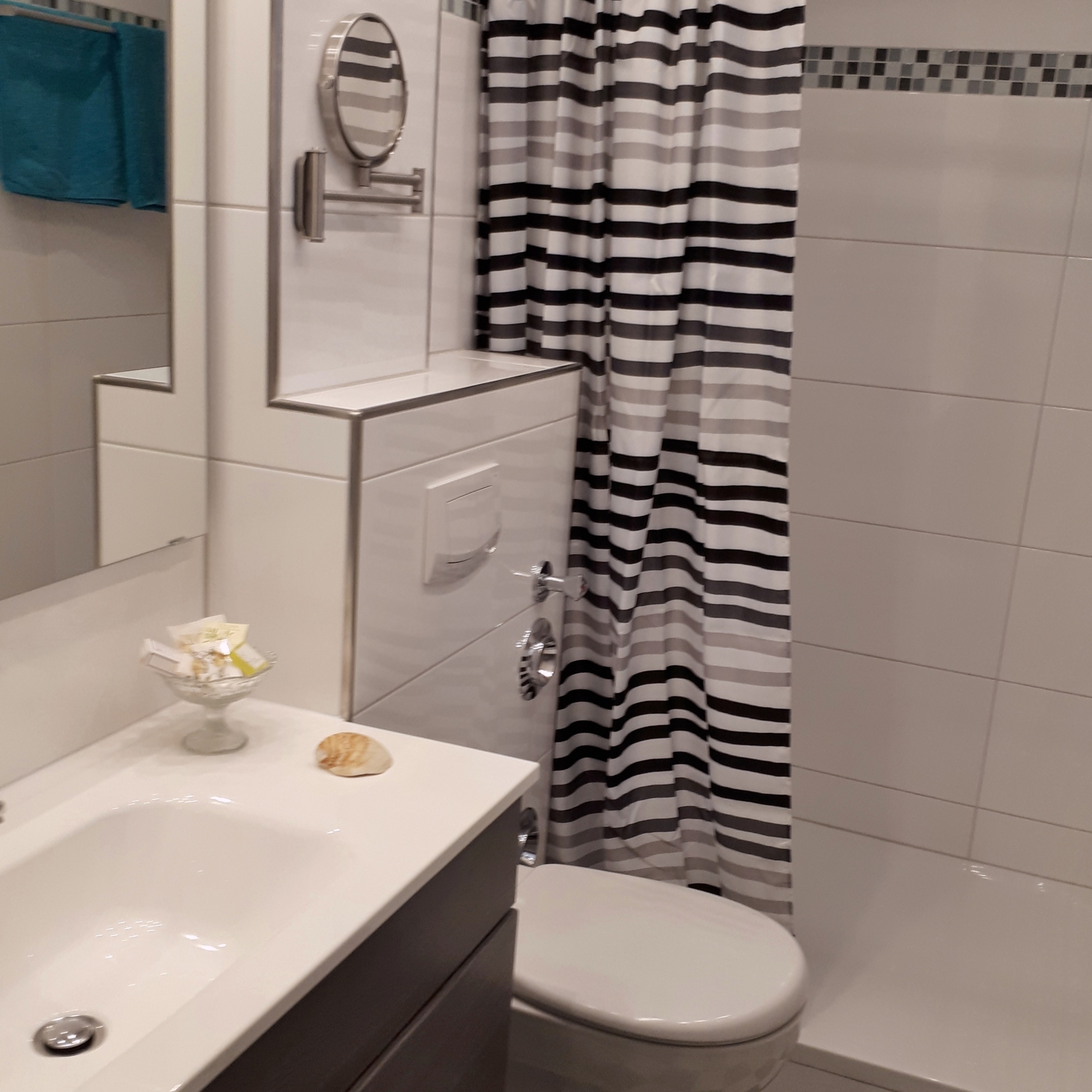 Blick ins Badezimmer mit Waschtisch und Dusche
